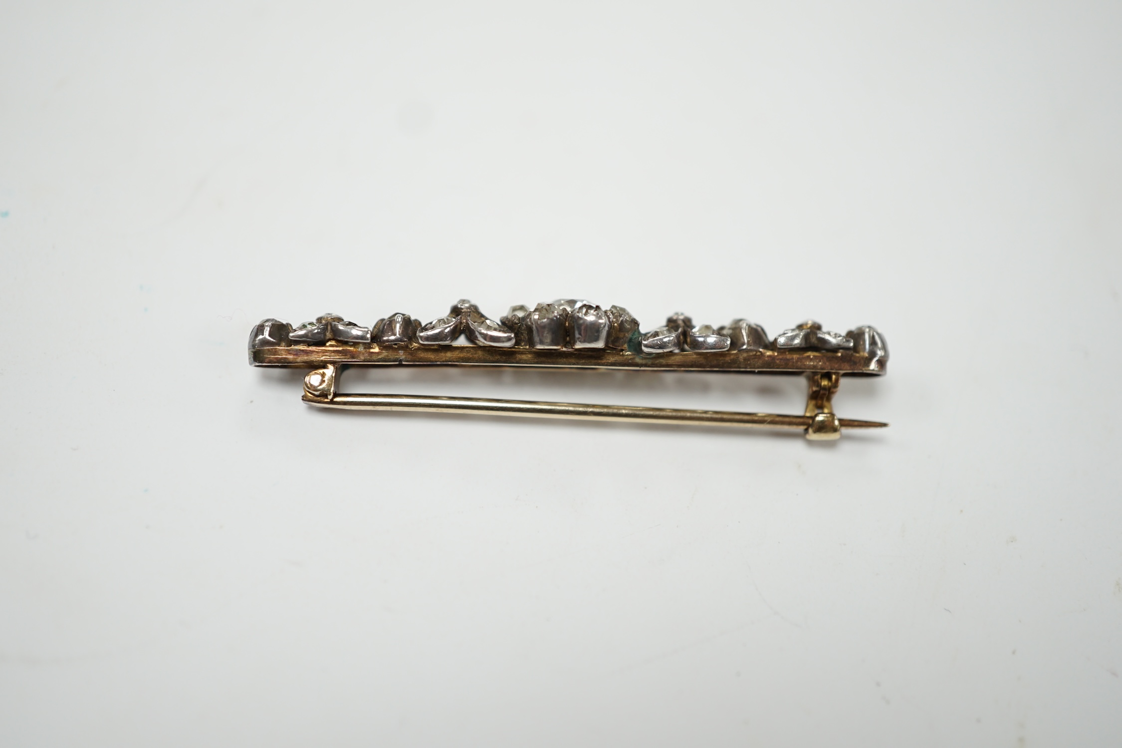 An early 19th century yellow metal and diamond cluster set bar brooch, 47mm, gross weight 4.3 grams. Fair condition.